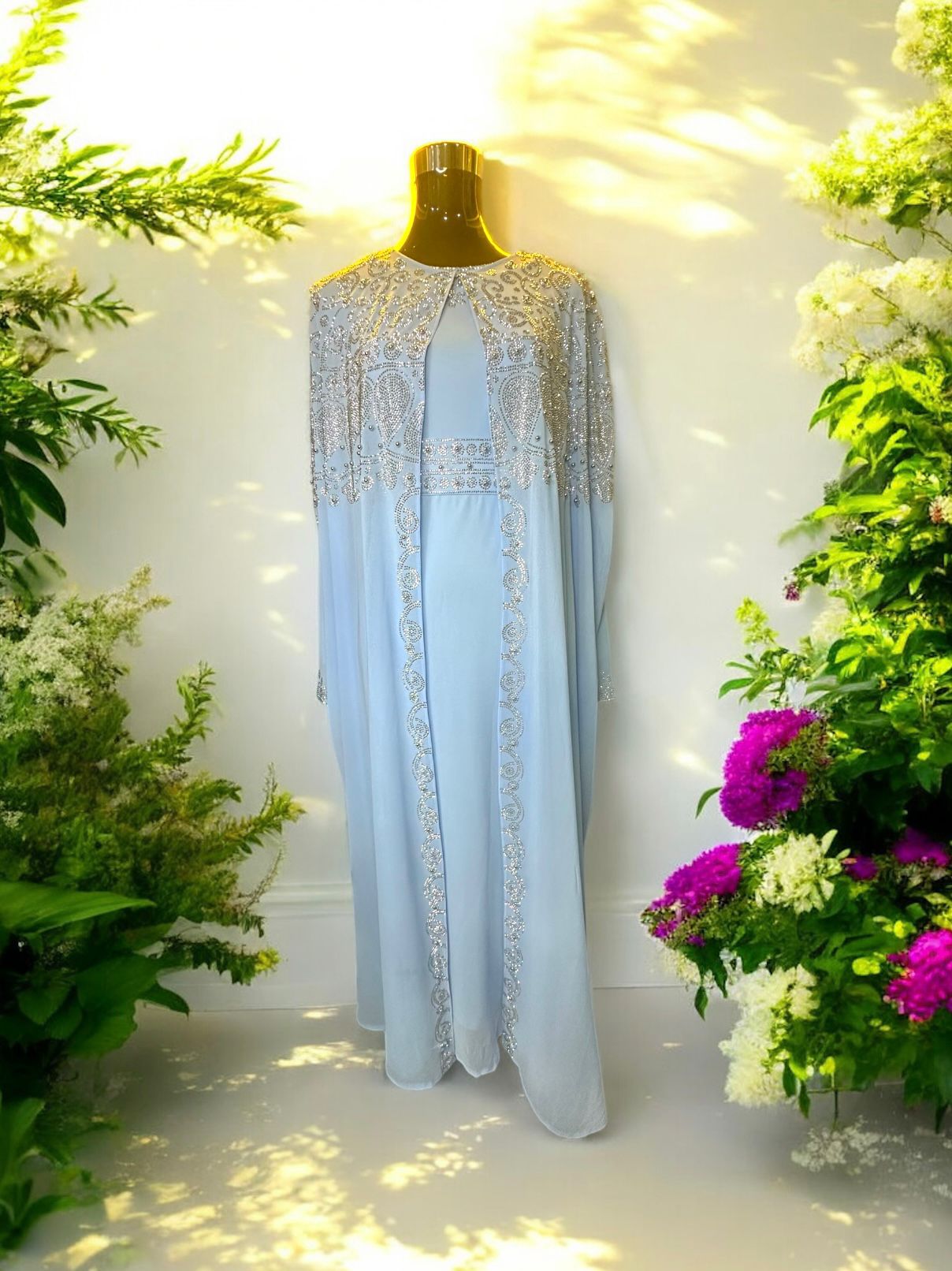 A Baby blue abaya designed with a flowing cape, delicately adorned with shimmering stone embellishments for a graceful and sophisticated finish.


