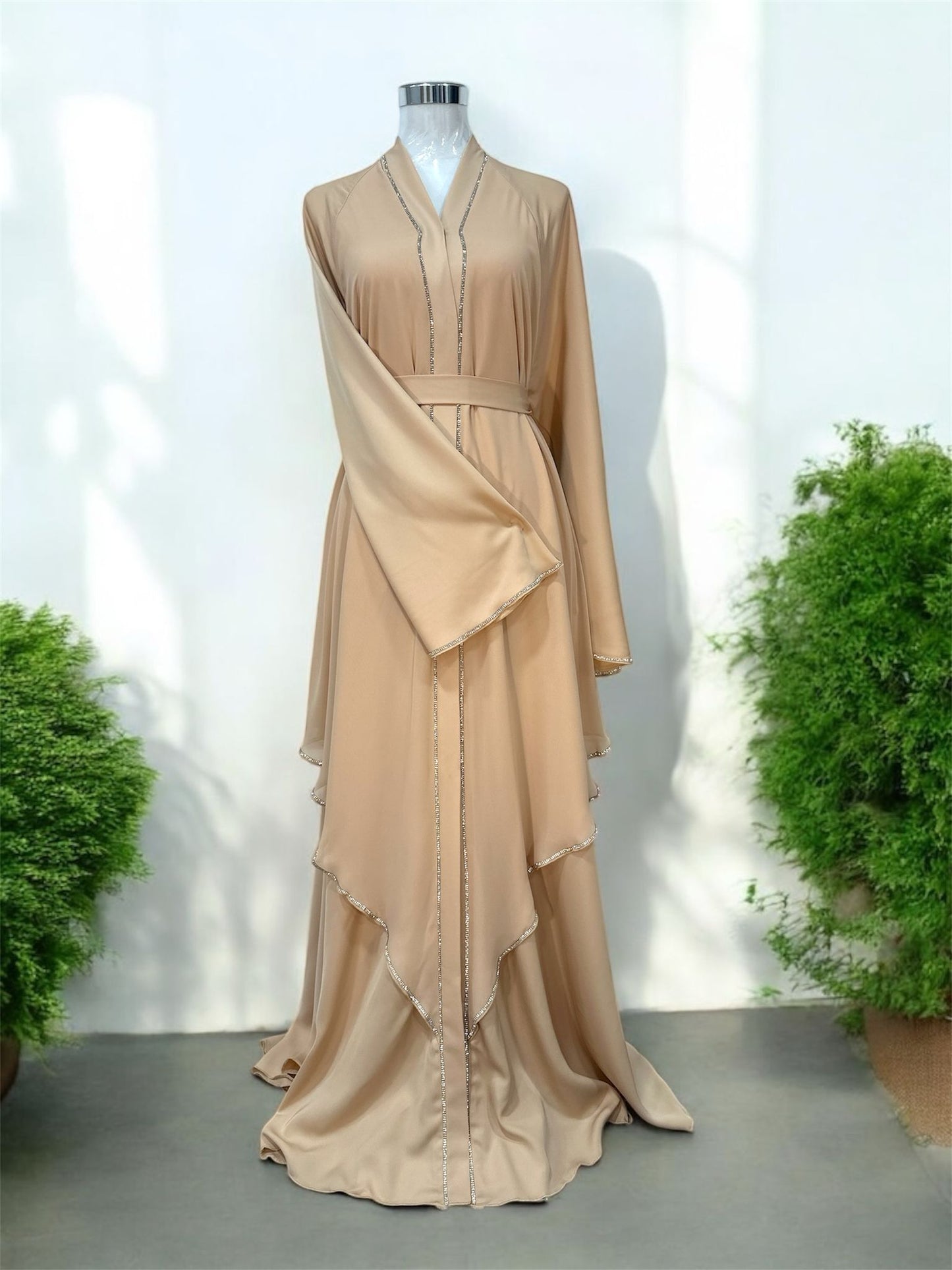 Malika Abaya was designed with flowing layered panels that create beautiful movement and a sophisticated silhouette. The delicate contrast trim detailing along the neckline, front panels, sleeves, and cascading layers adds a refined and modern touch.

Featuring wide flare sleeves and a matching waist belt, this piece offers both comfort and a flattering fit.
