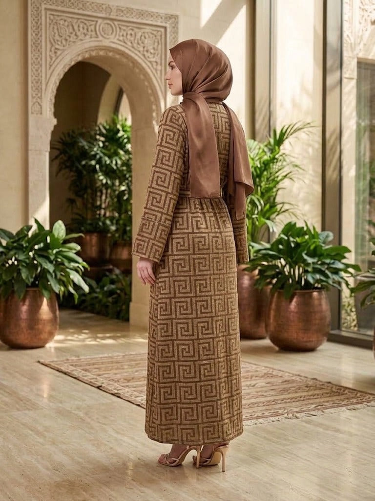 Our Mahaba Abaya ; featuring a graceful inner dress paired with a statement outer overcoat. The overcoat showcases a modern geometric pattern that adds a refined, contemporary touch, while its relaxed silhouette ensures effortless comfort.