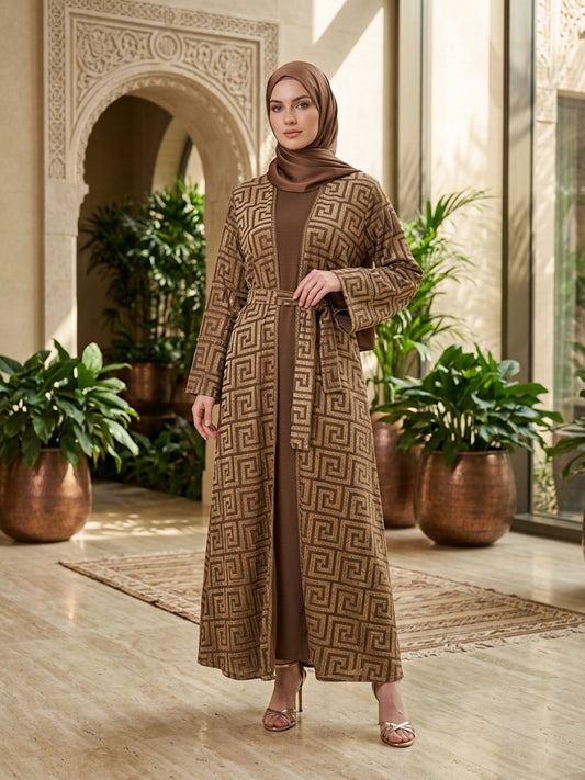 Our Mahaba Abaya ; featuring a graceful inner dress paired with a statement outer overcoat. The overcoat showcases a modern geometric pattern that adds a refined, contemporary touch, while its relaxed silhouette ensures effortless comfort.