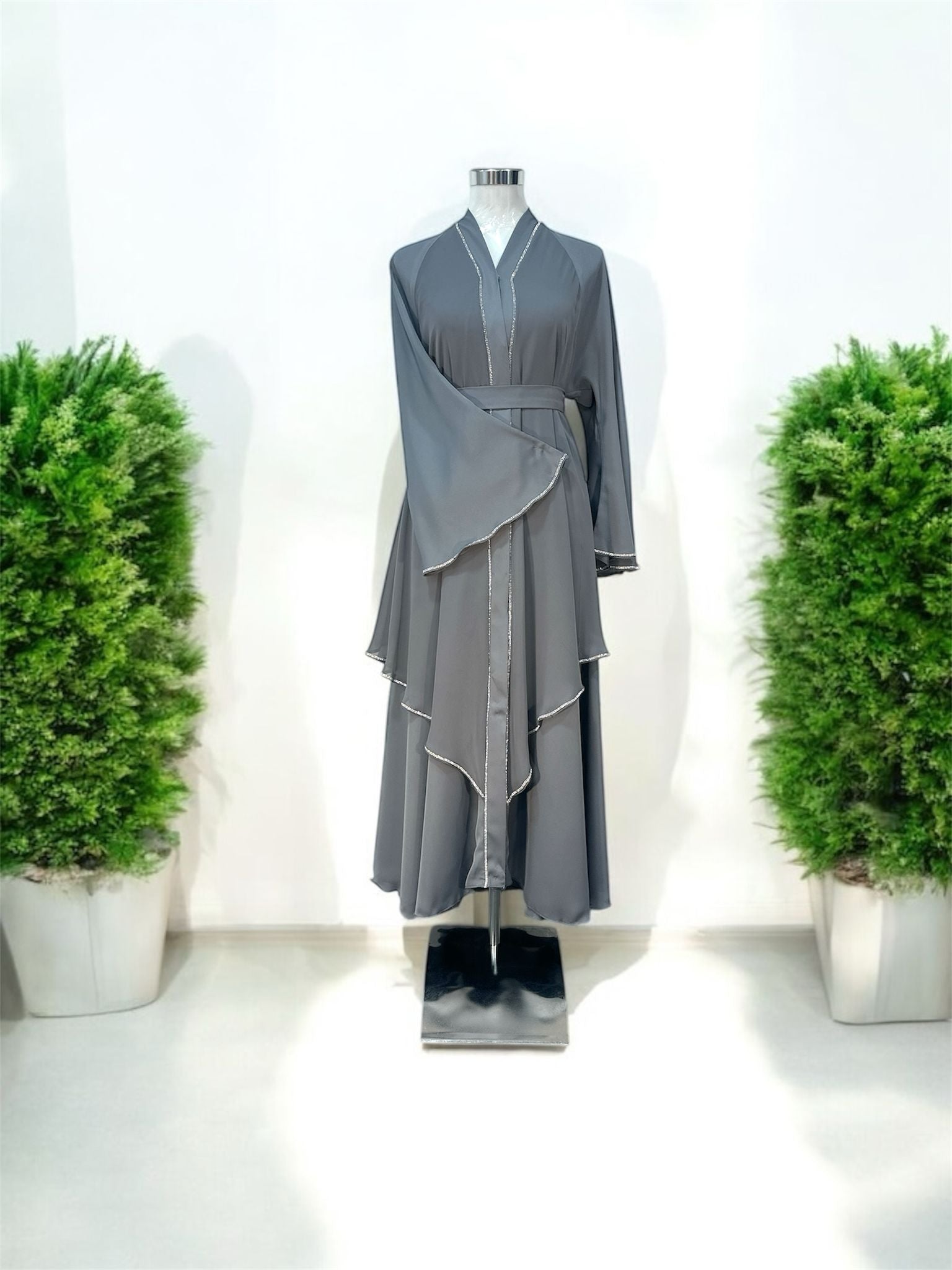 Malika Abaya was designed with flowing layered panels that create beautiful movement and a sophisticated silhouette. The delicate contrast trim detailing along the neckline, front panels, sleeves, and cascading layers adds a refined and modern touch.

Featuring wide flare sleeves and a matching waist belt, this piece offers both comfort and a flattering fit.