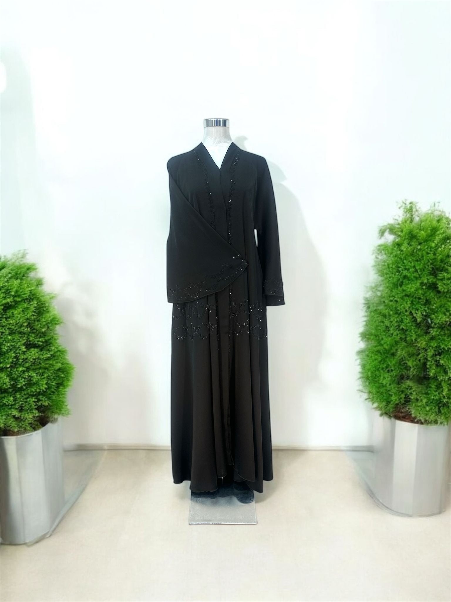 Featuring a structured shawl collar neckline, it brings a polished and sophisticated touch to a beautifully fluid silhouette.&nbsp;Delicate linear embellishments are thoughtfully placed along the front and throughout the skirt, creating a subtle shimmer that enhances movement and elongates the figure.