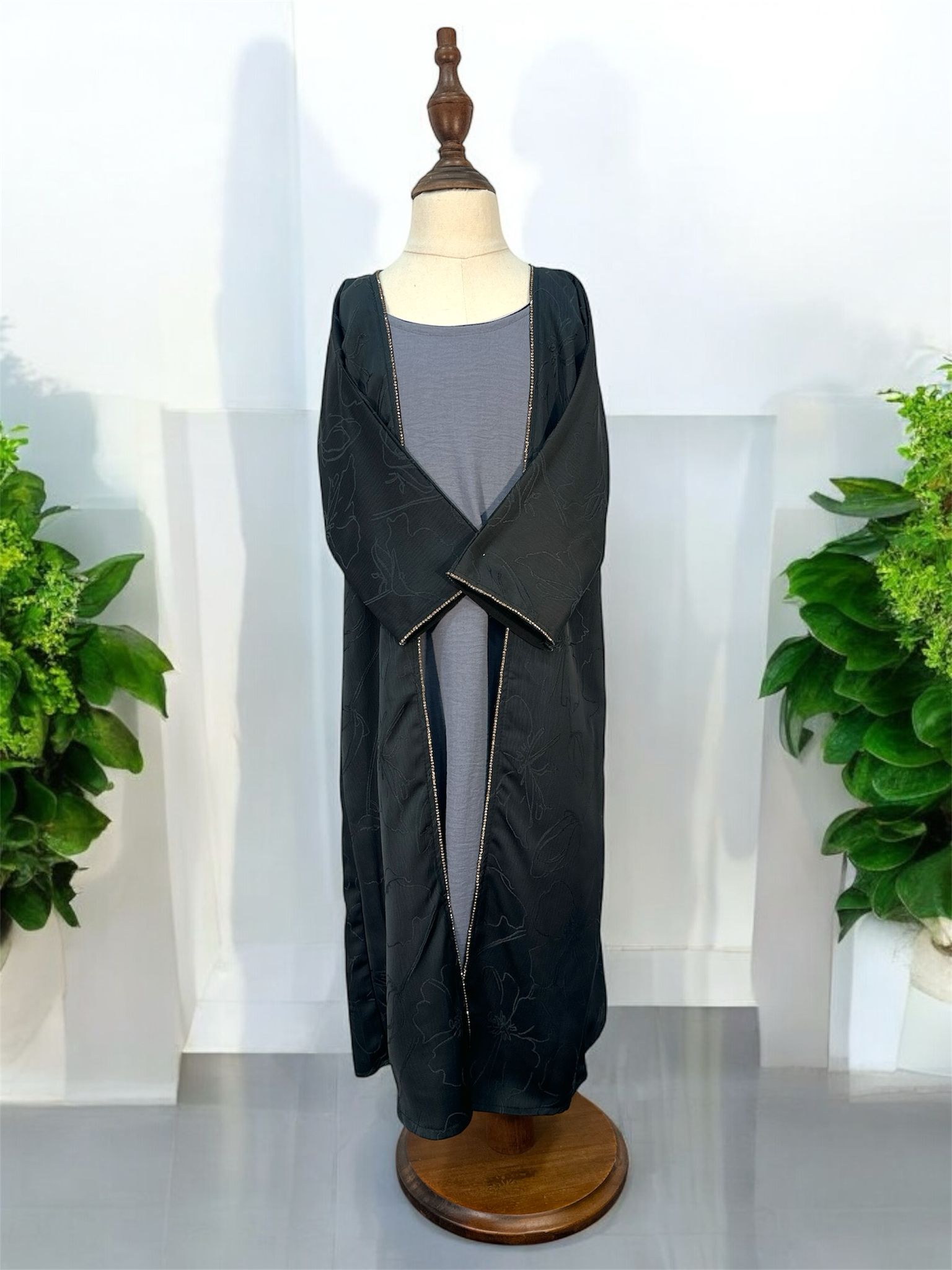 A sophisticated open-front abaya designed with understated elegance and modern refinement. Designed with wide relaxed sleeves and a loose flowing cut, this abaya offers both comfort and effortless style, making it perfect for layering over inner dresses or casual ensembles. Crafted from smooth, lightweight fabric, this piece features a subtle floral-textured pattern that adds depth and luxury to its timeless silhouette.