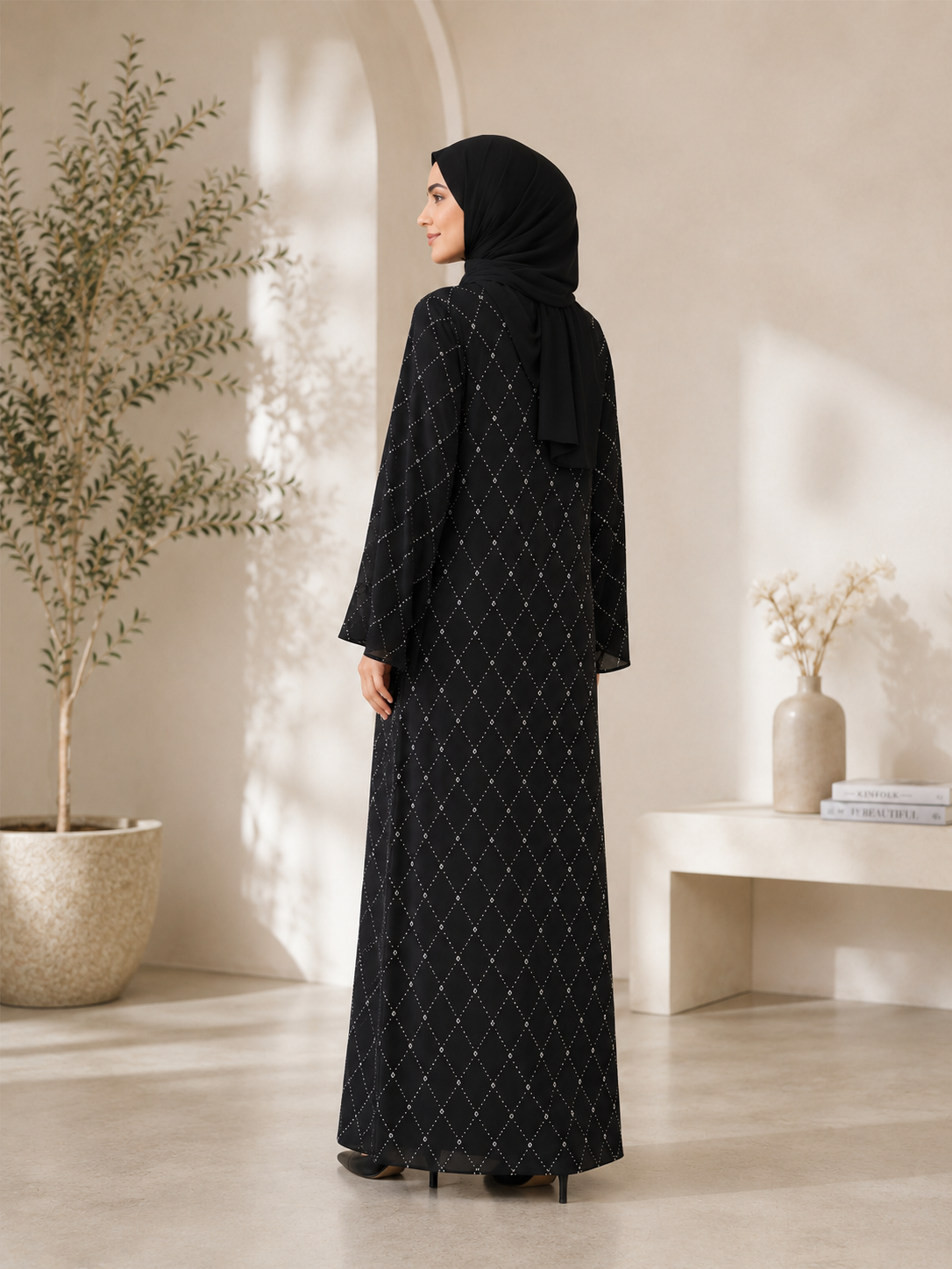 Black closed abaya with V-neck, small whites stones across abaya and adorned with raised stones that added texture and sparkles