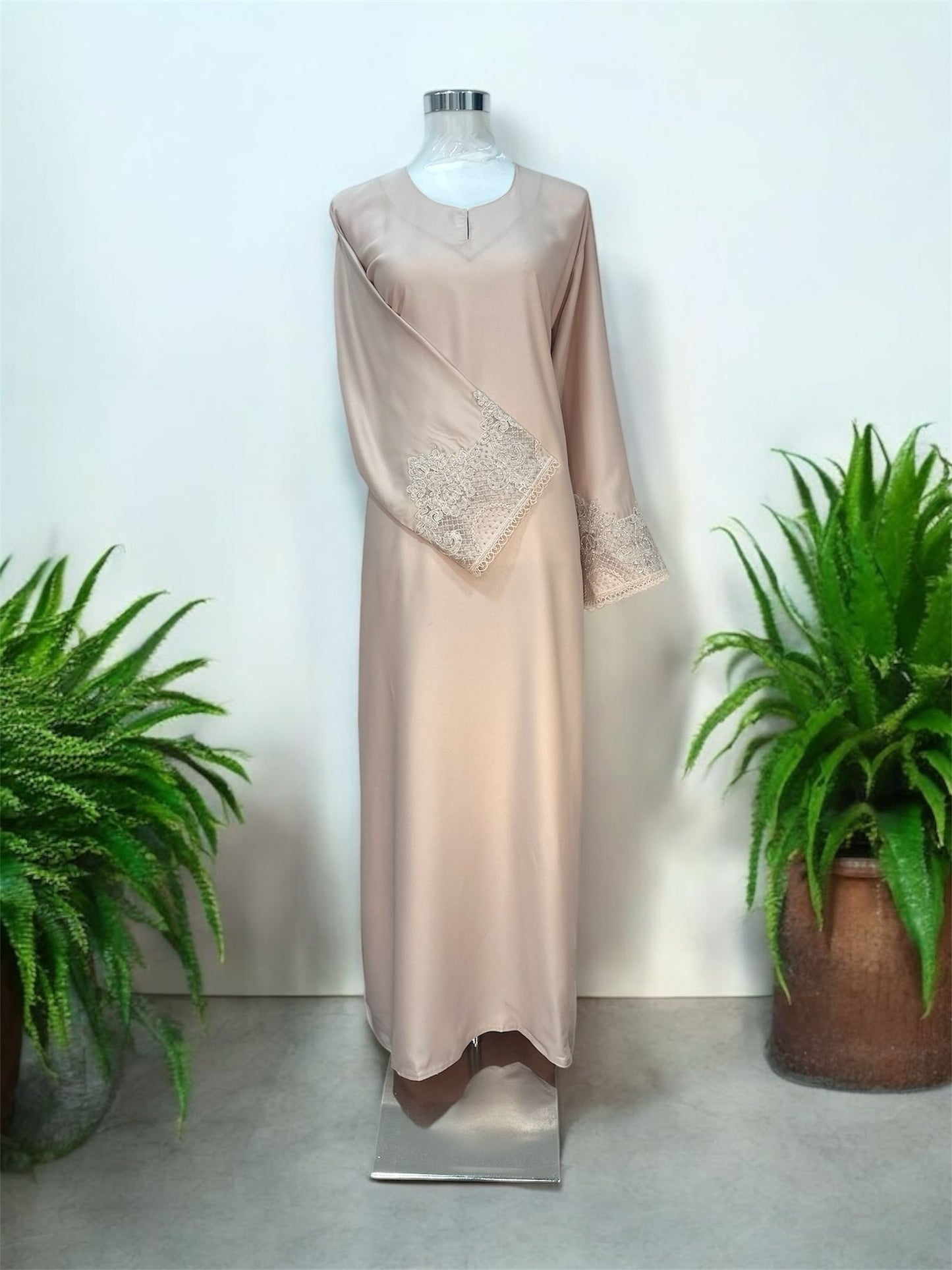 Light Peach Nisa jubah falls in a clean, elongated line, creating a flattering drape that moves beautifully with every step. A subtle V-notched round neckline adds a modern touch, while the standout feature lies in the delicately crafted lace cuffs—intricately detailed to elevate the overall design with a hint of femininity and refinement and it is paired with a shawl.