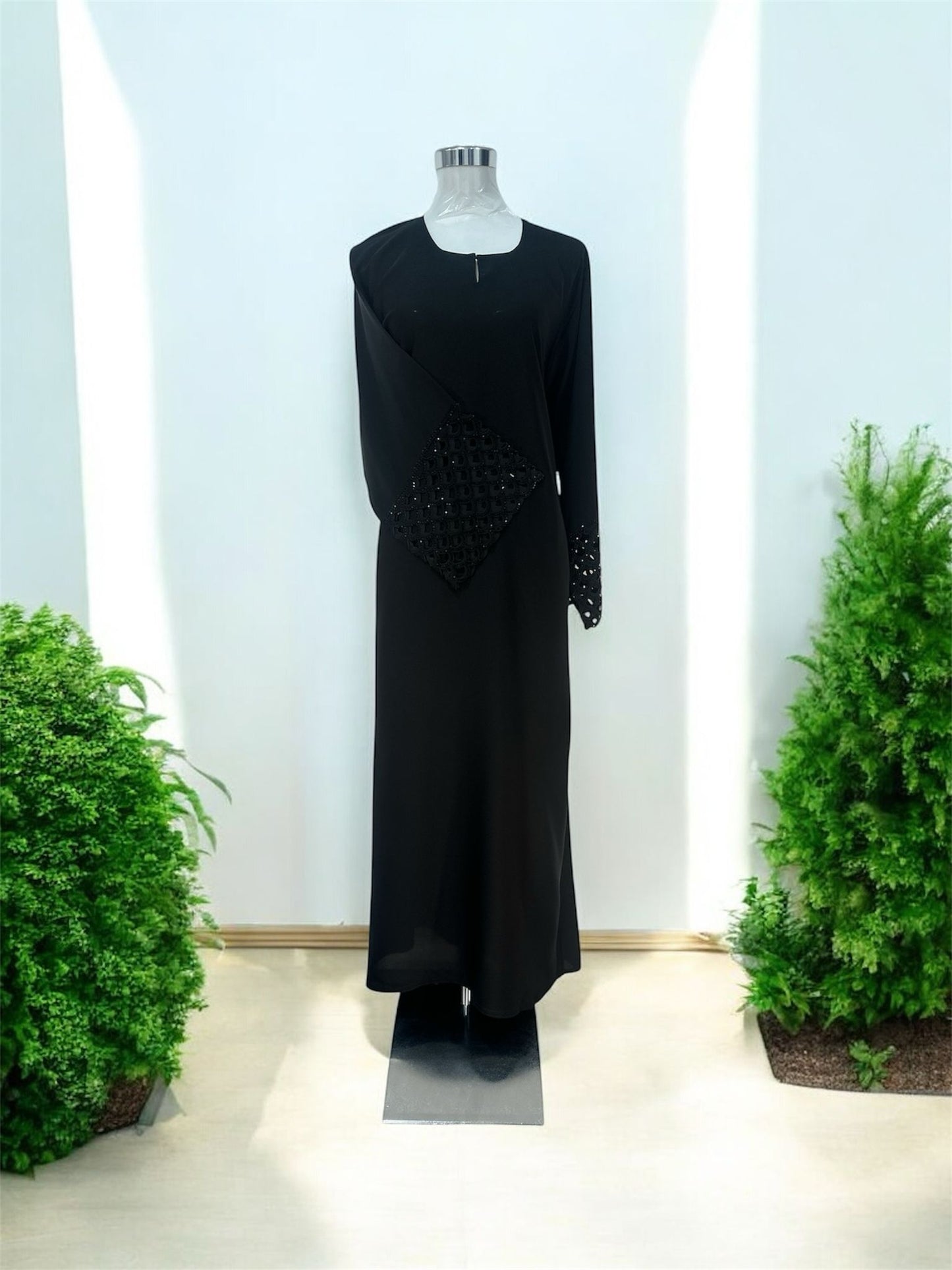 Black Nisa jubah falls in a clean, elongated line, creating a flattering drape that moves beautifully with every step. A subtle V-notched round neckline adds a modern touch, while the standout feature lies in the delicately crafted lace cuffs—intricately detailed to elevate the overall design with a hint of femininity and refinement and it is paired with a shawl.