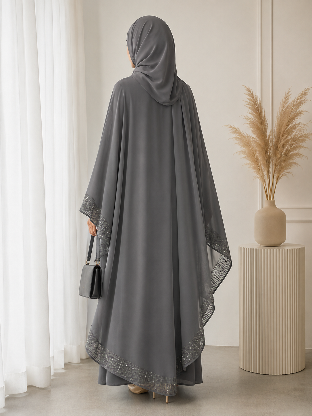 A grey jubah with a sew in flowing cape, featuring delicate bead embroidery across the cape for a graceful, understated elegance. Comes complete with a matching shawl.