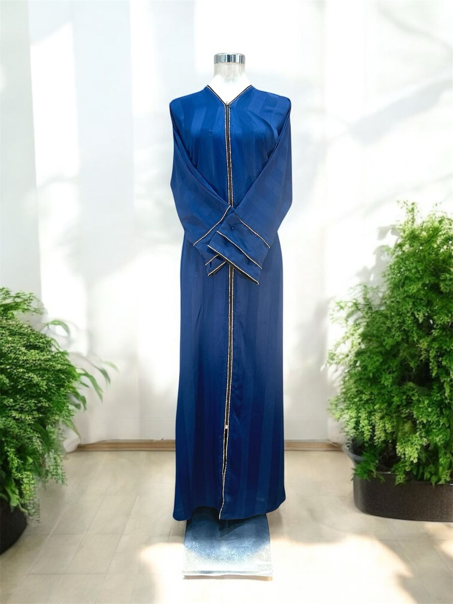 Our Nadra Abaya features sleek front opening with a central zip closure, framed by fine gold accents that elongate the figure and create a polished finish, subtly textured fabric enhances its overall elegance and comes with a shawl.