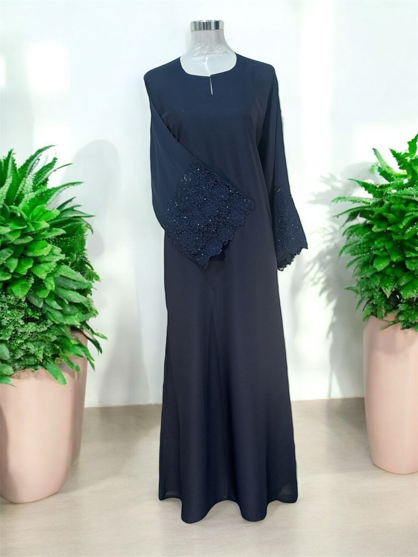 Navy Nisa jubah falls in a clean, elongated line, creating a flattering drape that moves beautifully with every step. A subtle V-notched round neckline adds a modern touch, while the standout feature lies in the delicately crafted lace cuffs—intricately detailed to elevate the overall design with a hint of femininity and refinement and it is paired with a shawl.