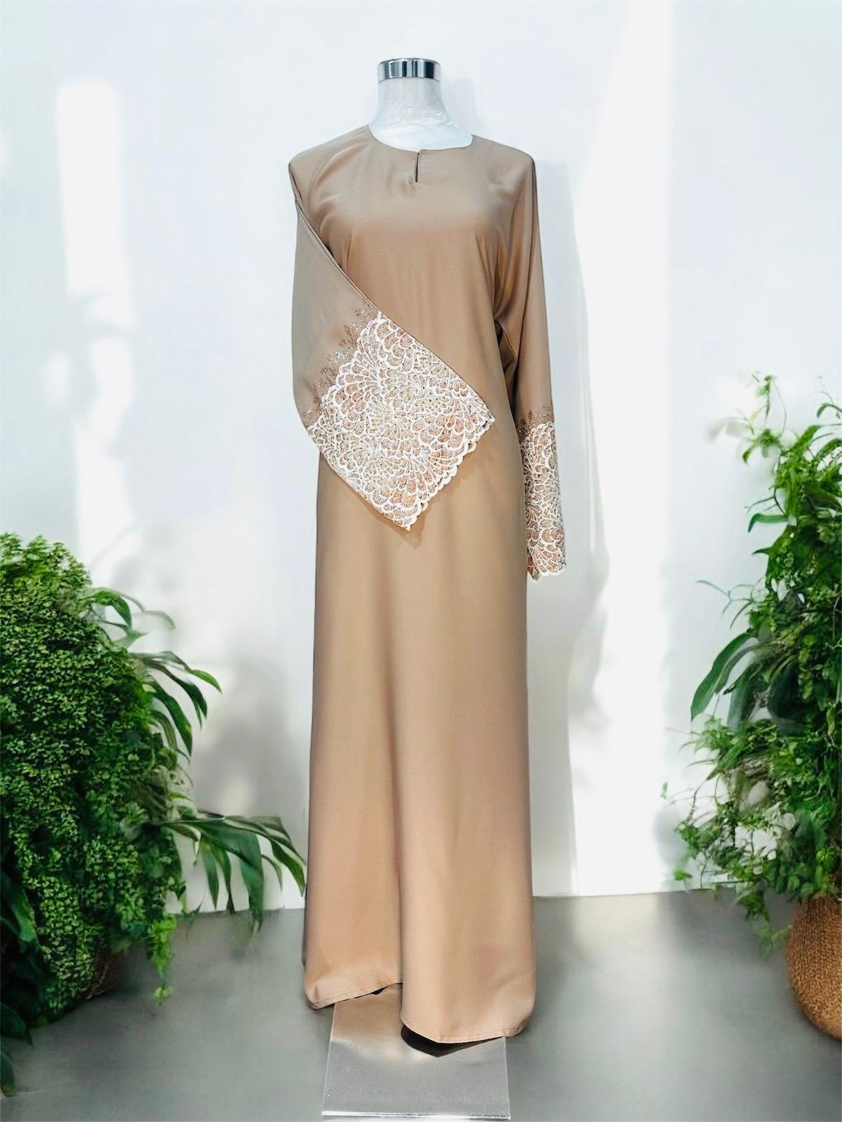 Nude Brown Nisa jubah falls in a clean, elongated line, creating a flattering drape that moves beautifully with every step. A subtle V-notched round neckline adds a modern touch, while the standout feature lies in the delicately crafted lace cuffs—intricately detailed to elevate the overall design with a hint of femininity and refinement and it is paired with a shawl.