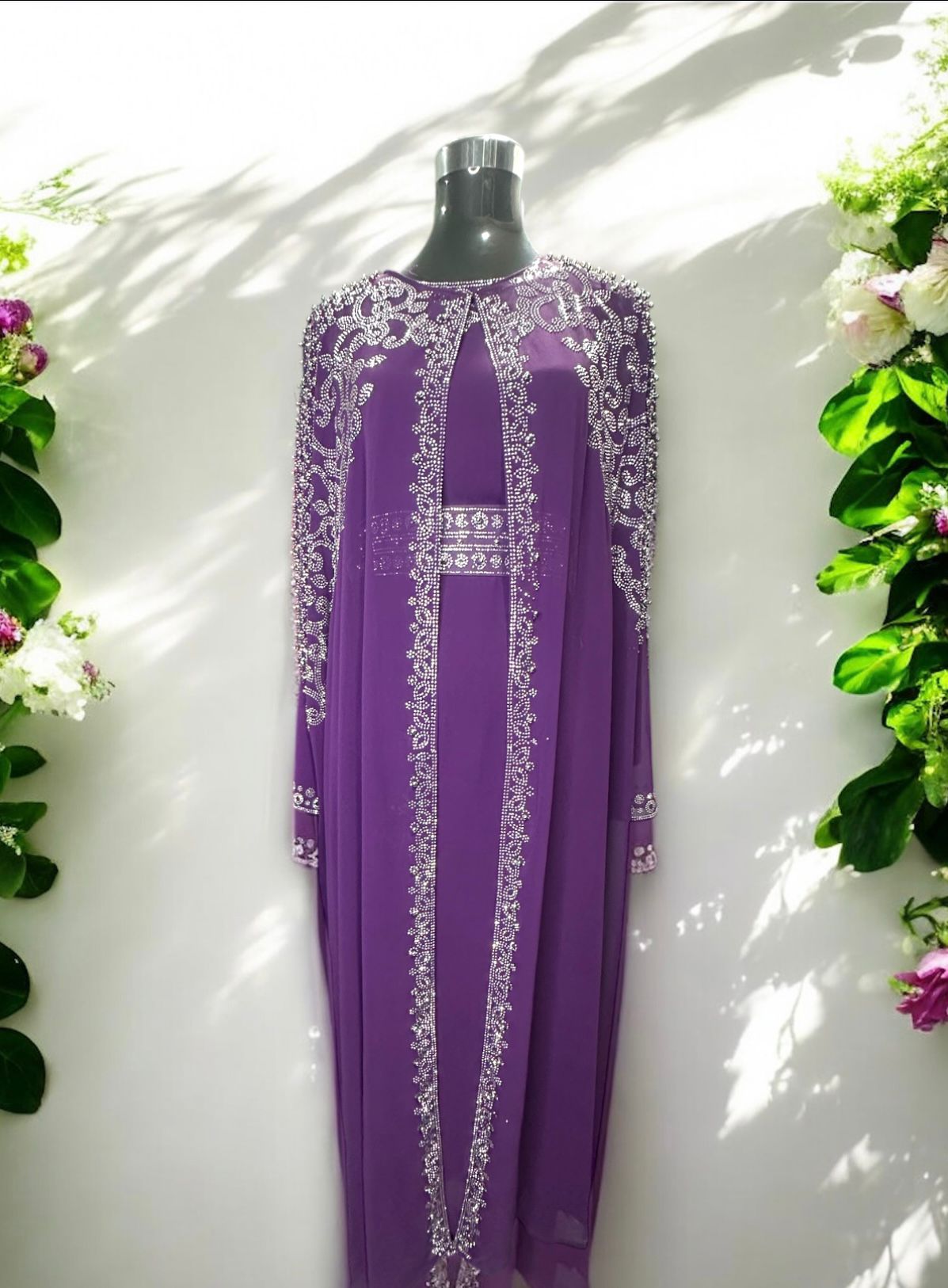 A Purple abaya designed with a flowing cape, delicately adorned with shimmering stone embellishments for a graceful and sophisticated finish.


