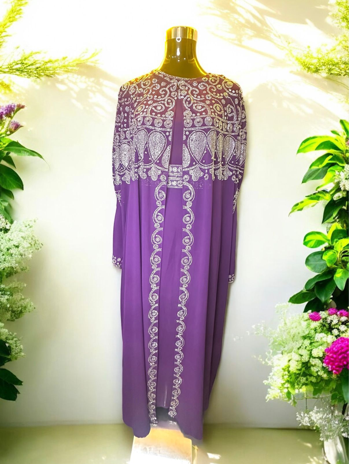 A Purple abaya designed with a flowing cape, delicately adorned with shimmering stone embellishments for a graceful and sophisticated finish.


