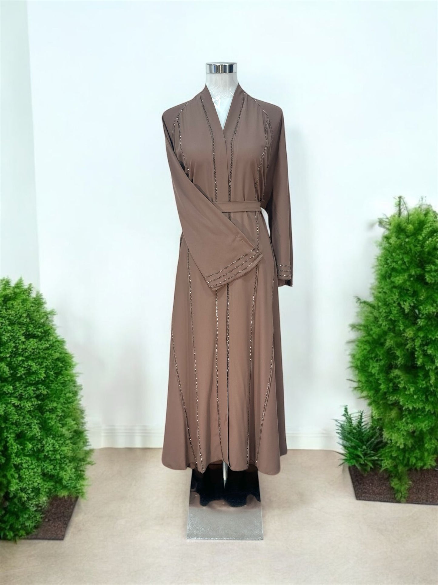 Featuring a structured shawl collar neckline, it brings a polished and sophisticated touch to a beautifully fluid silhouette. Delicate linear embellishments are thoughtfully placed along the front and throughout the skirt, creating a subtle shimmer that enhances movement and elongates the figure.