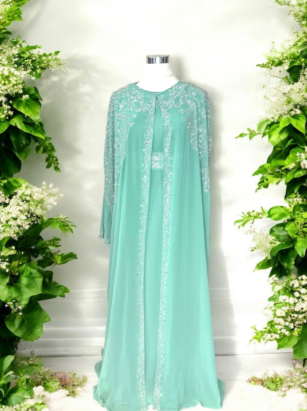 A Turquoise abaya designed with a flowing cape, delicately adorned with shimmering stone embellishments for a graceful and sophisticated finish.