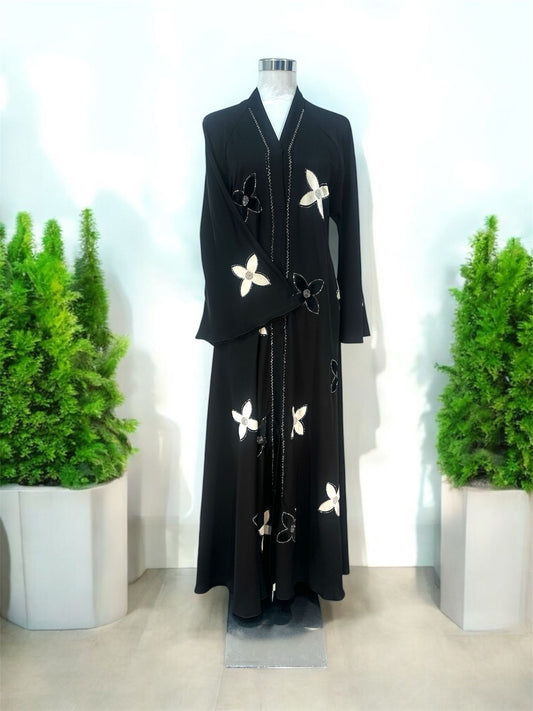 Our Yasmin Abaya is enhanced with delicate snap-button blossom accents across the overcoat and sleeves, adding texture and a unique decorative touch and elevated with subtle stone embellishments along the slit, offering a hint of understated sparkle, while the coordinating shawl completes the ensemble with effortless elegance.